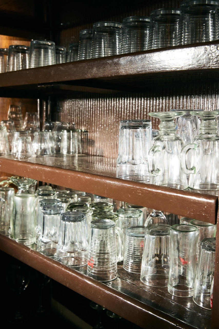 Shelves of glassware in warm brown light
