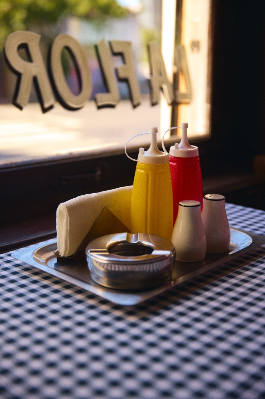 Sauce bottles and a sugar pot on a tray by the window